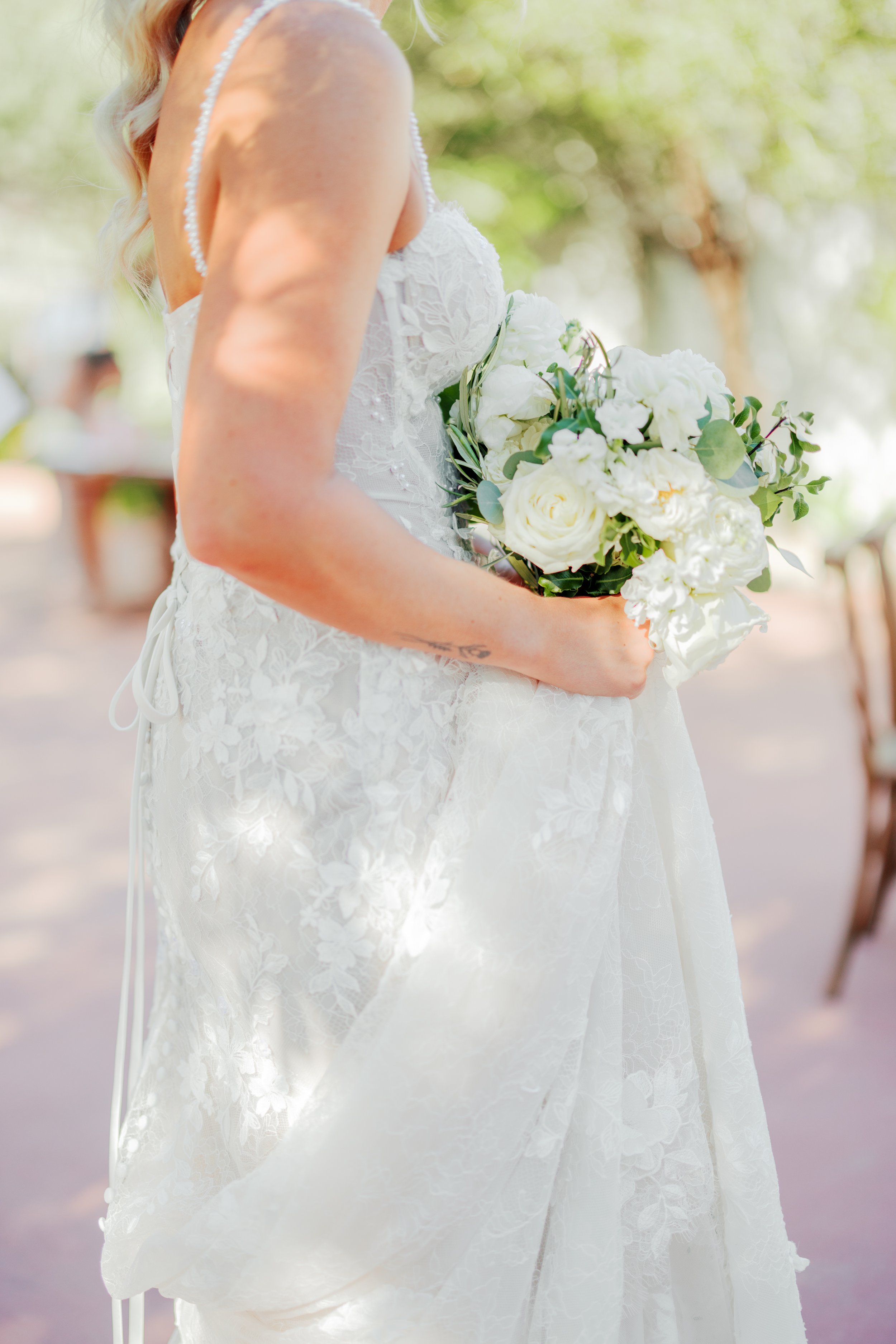Wedding bride holding her bouquet with shadows artfully illuminating her bouquet