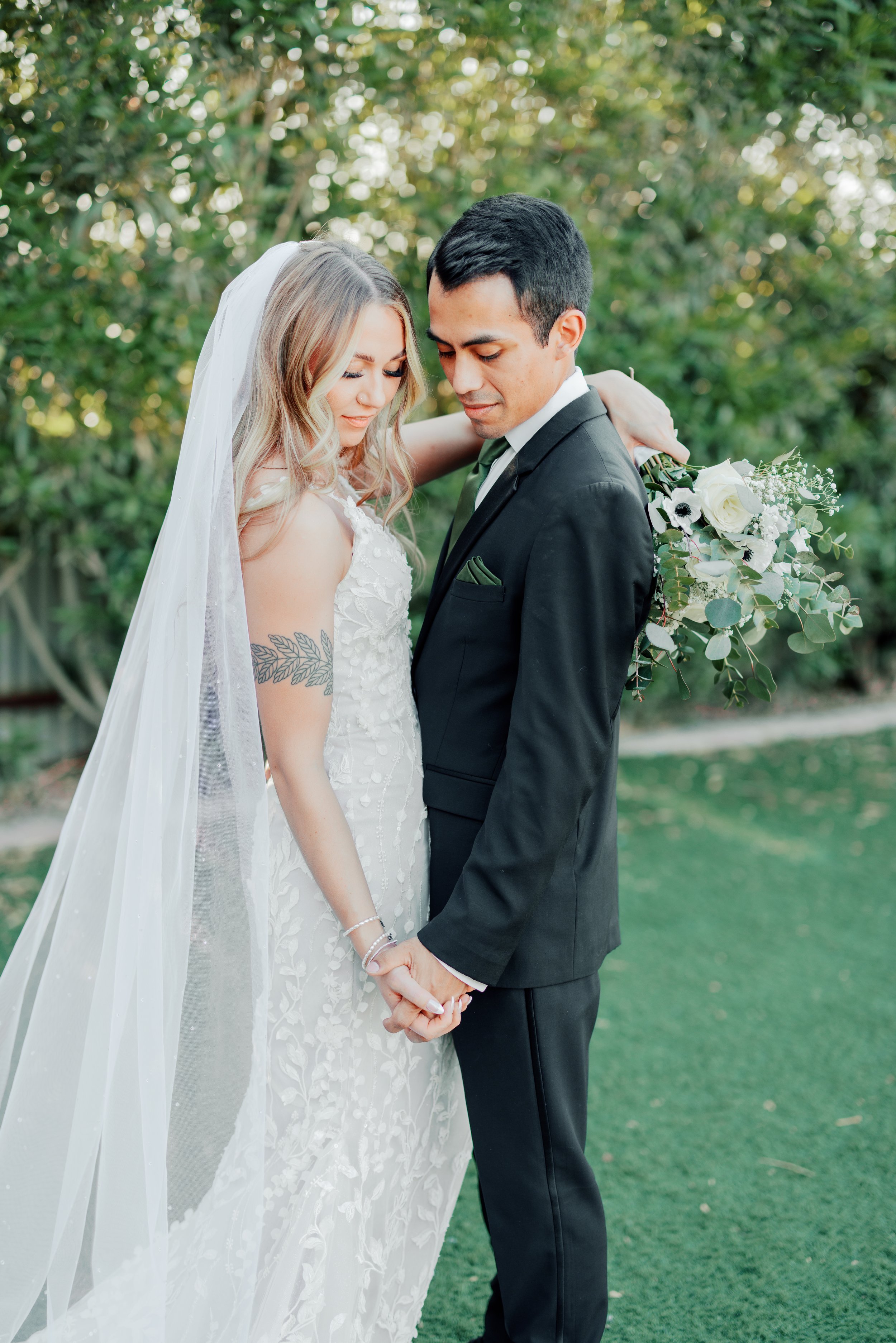 bride and groom after they are married holding hands and posing in front of the photographer for their formal photos at their wedding venue Big Tin Cotton Gin