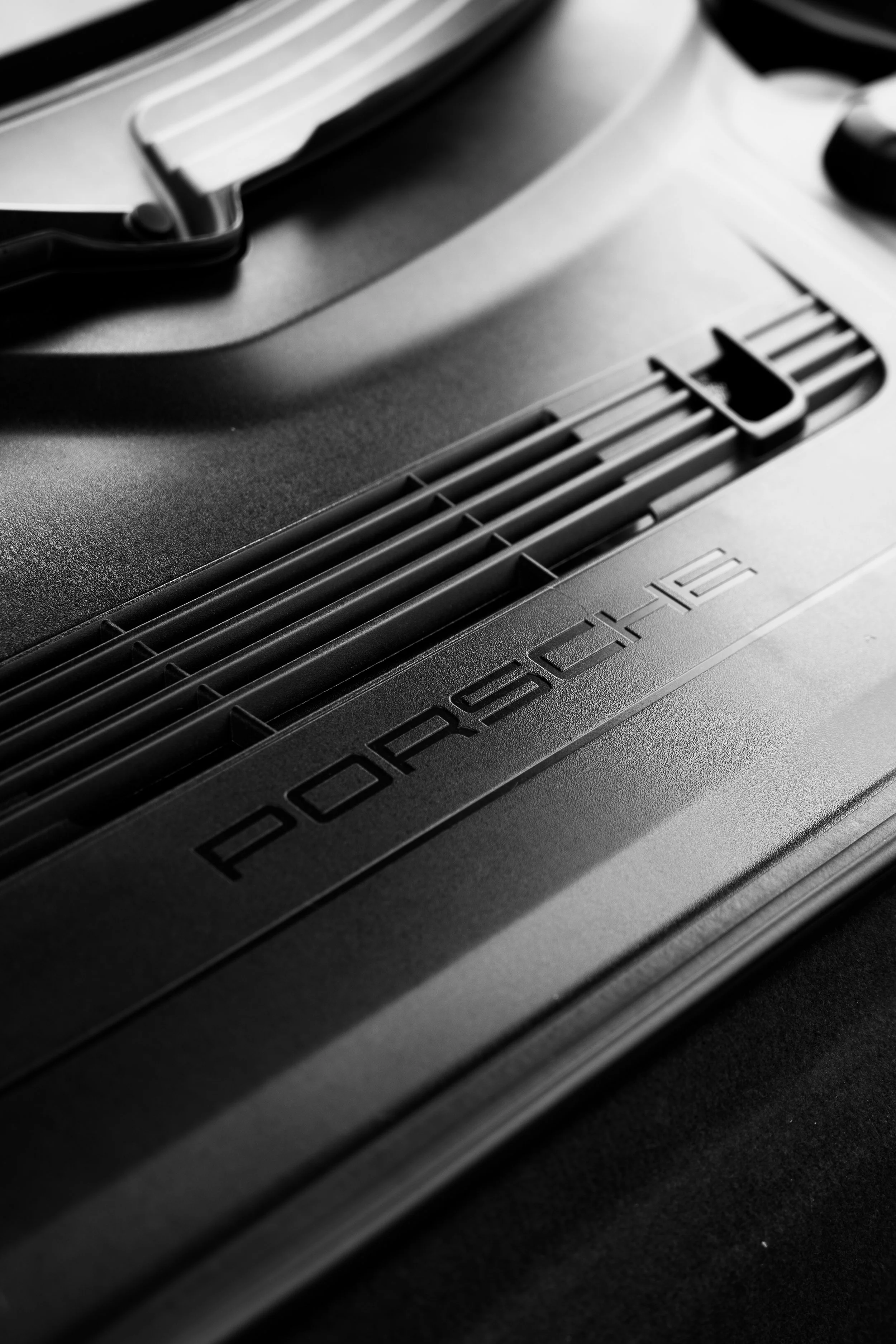 Close-up of a black and gray Ferrari engine with visible grilles and embossed brand name.