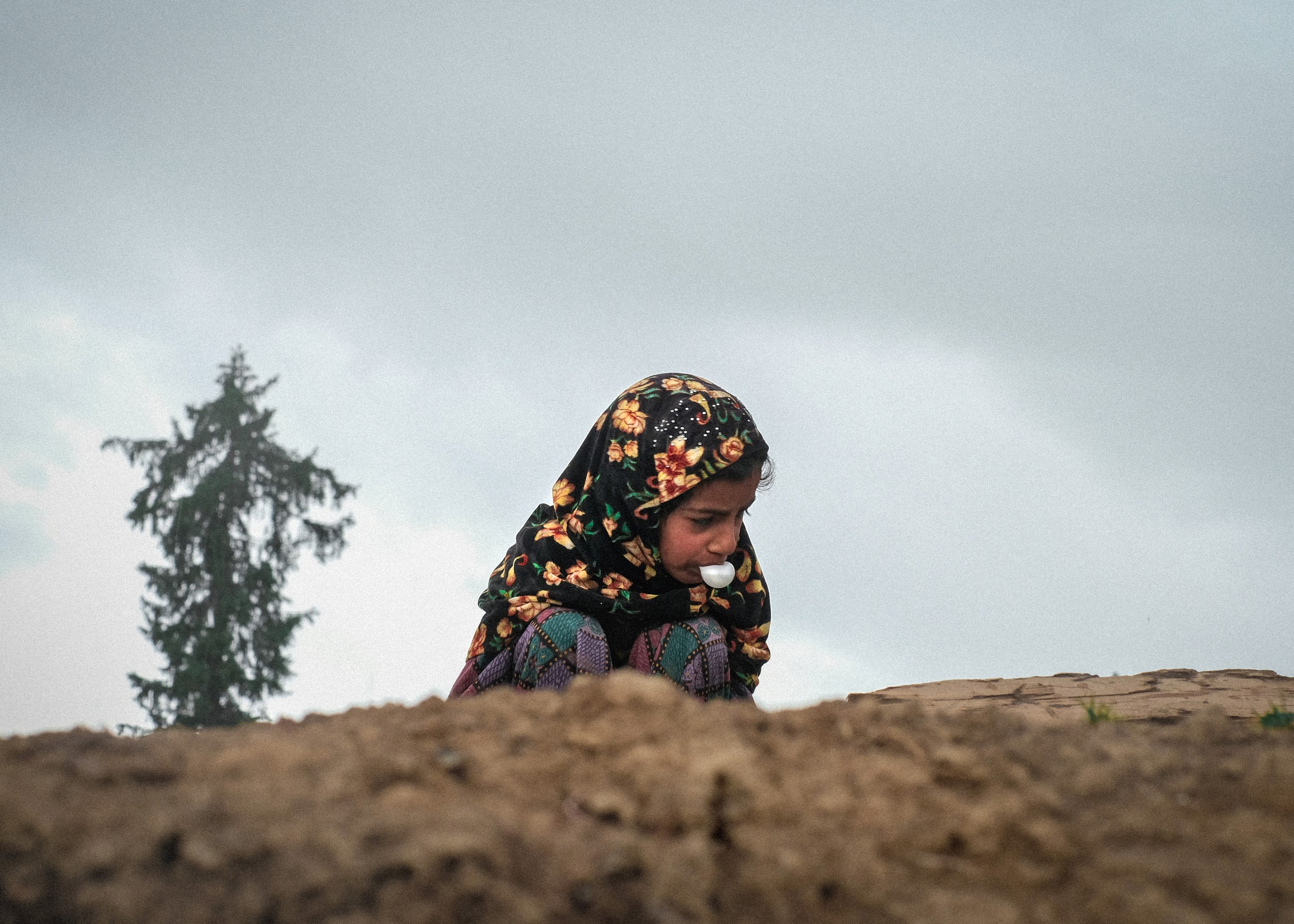 Bakarwal girl on the roof of a mud house in Budgam, Kashmir