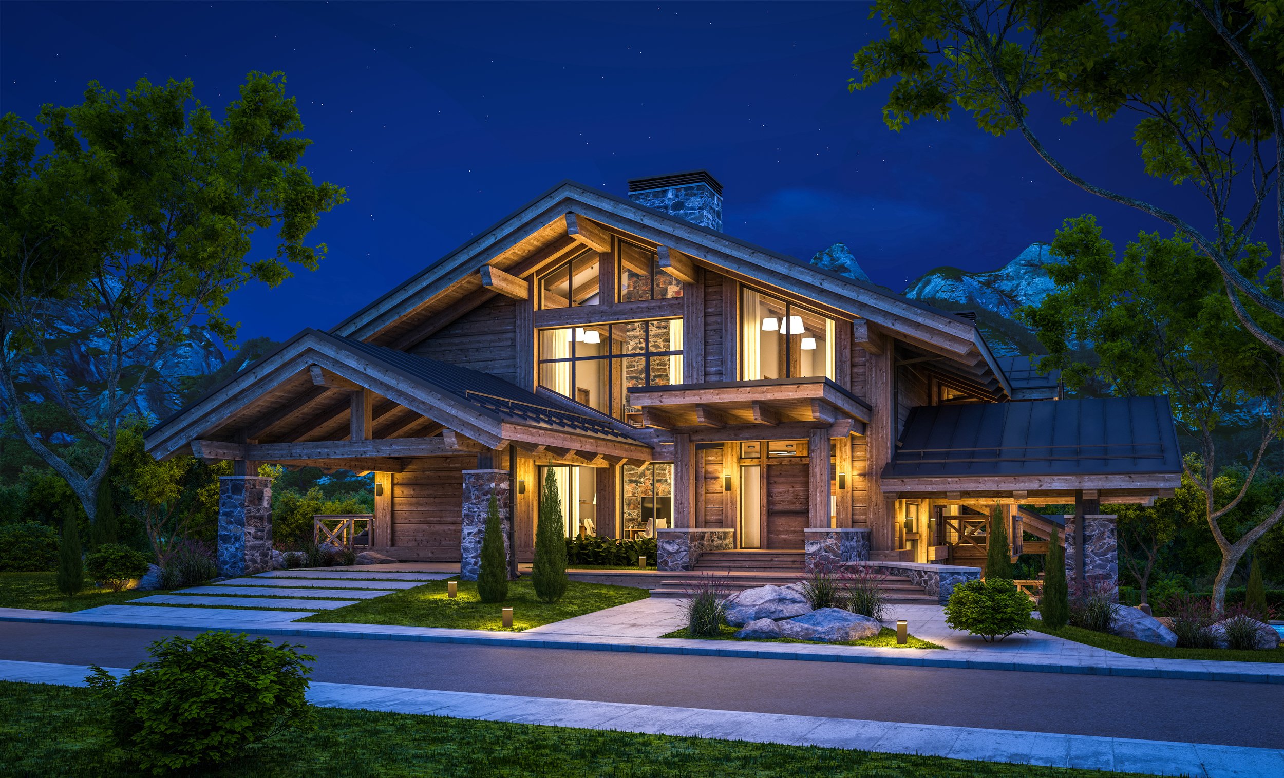 A modern wooden house illuminated at night, surrounded by trees and landscape, with mountains visible in the background and a clear starry sky.