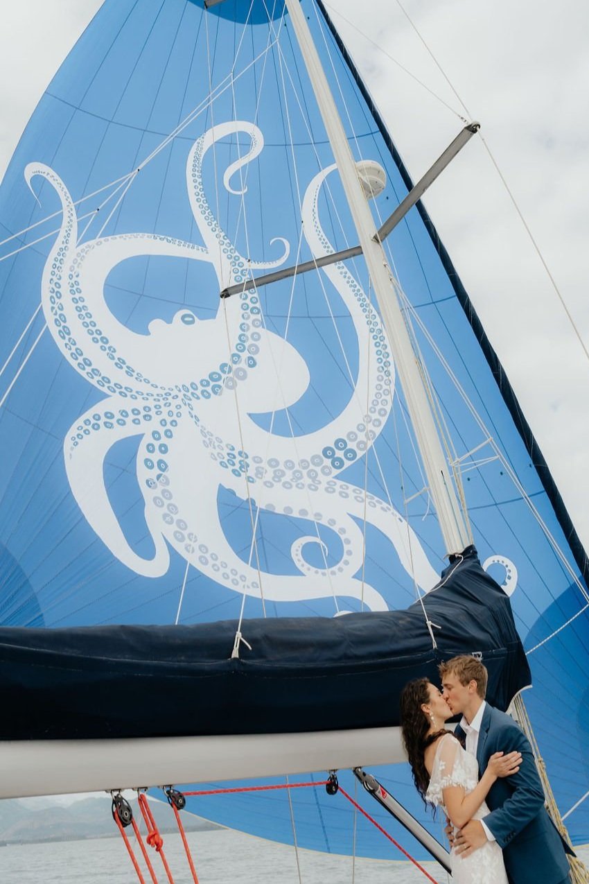 Couple kissing on sailboat with octopus design on blue sail