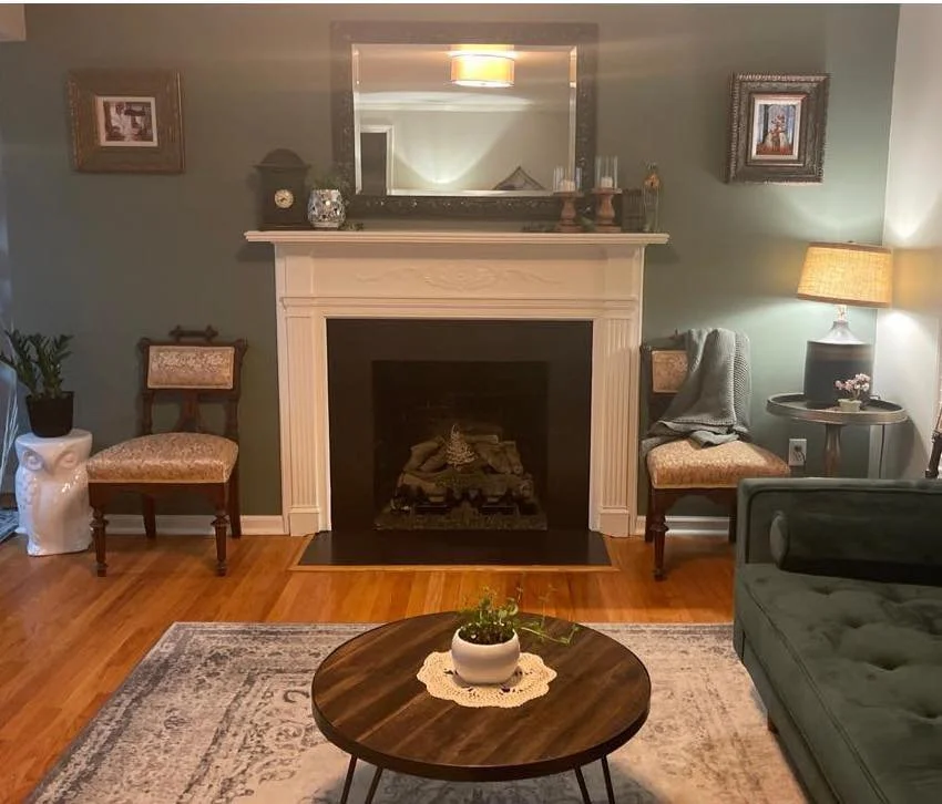 Living Room Makeover complete with art on the walls, 1880s antique chairs, plants and velvet green accent couch! My new favorite room!