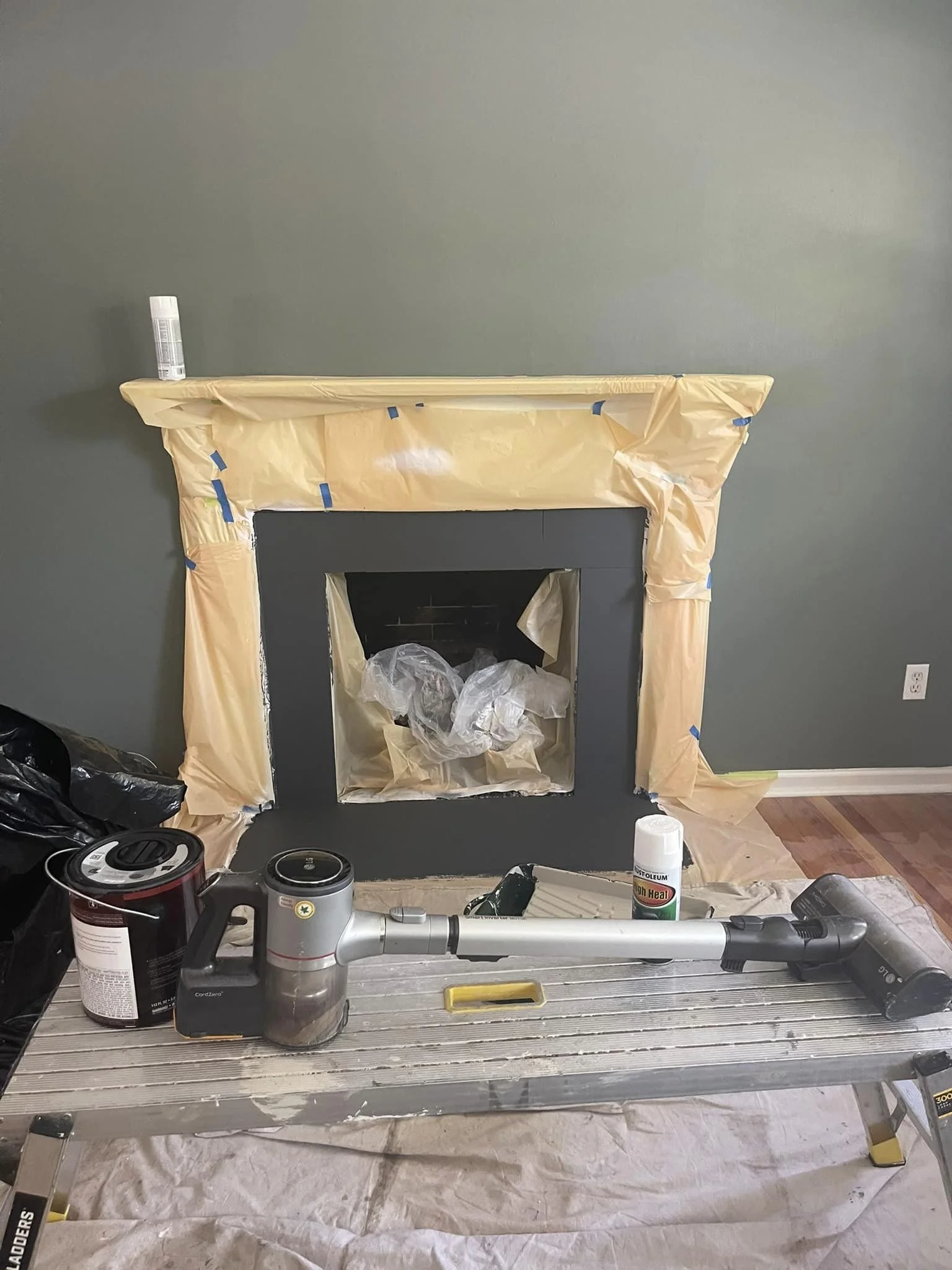 Taping off the mantle to paint the wall and tiles