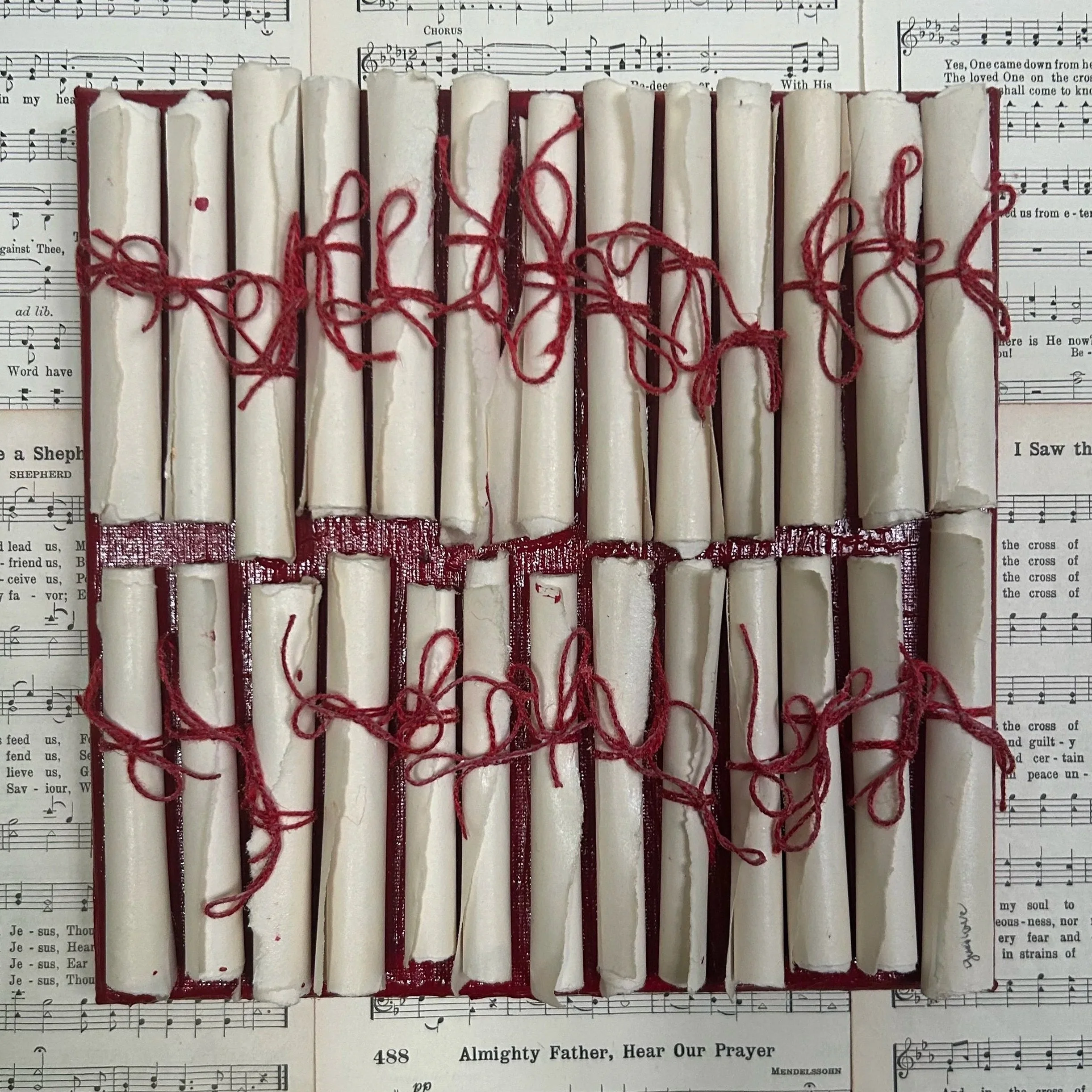 Rows of rolled sheet music scrolls tied with red thread