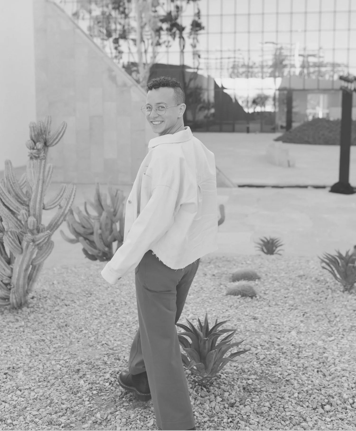 Avery smiling at the camera outdoors among desert plants.