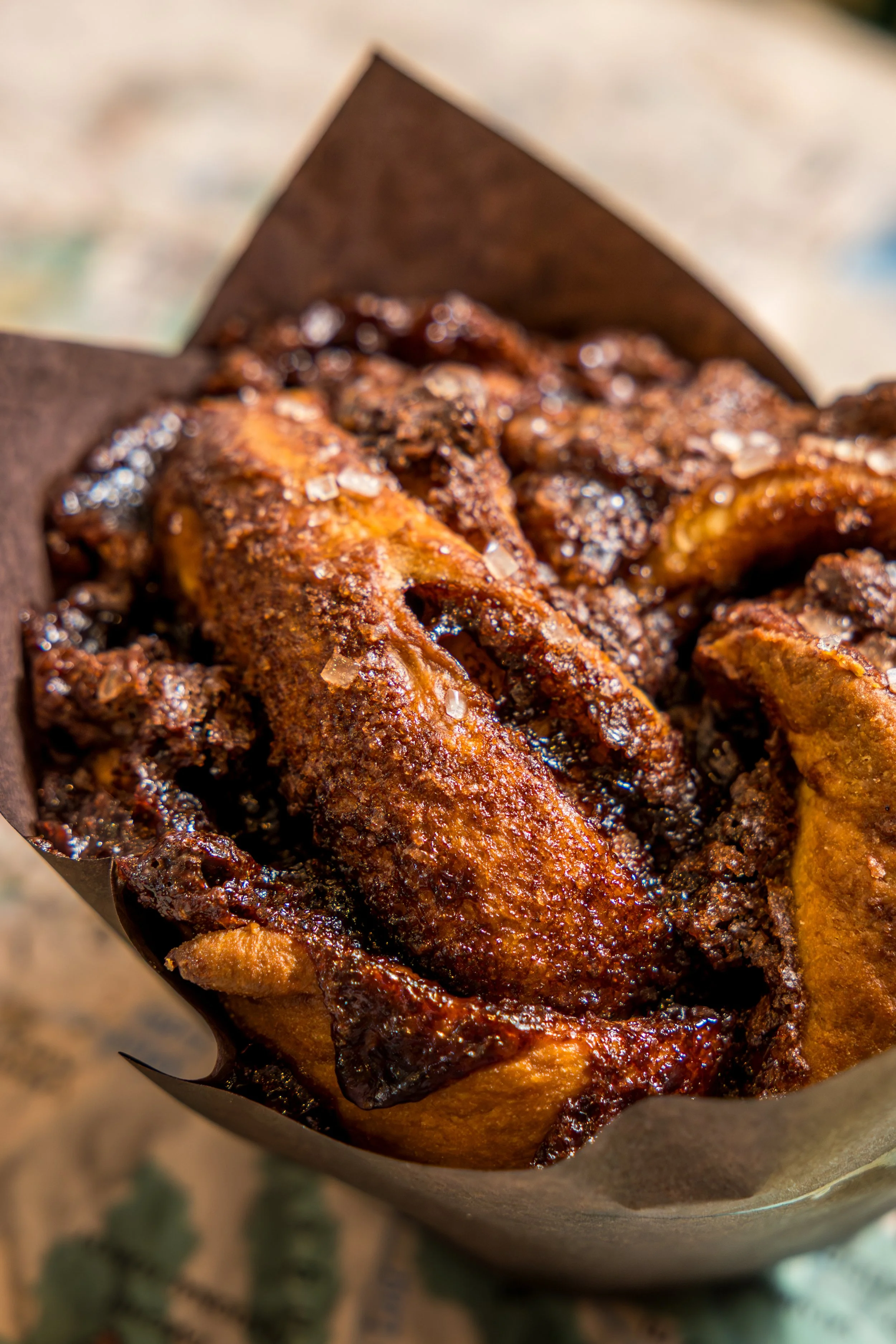 Close-up of a cone of deep-fried chicken wings coated with seasoning and spices.