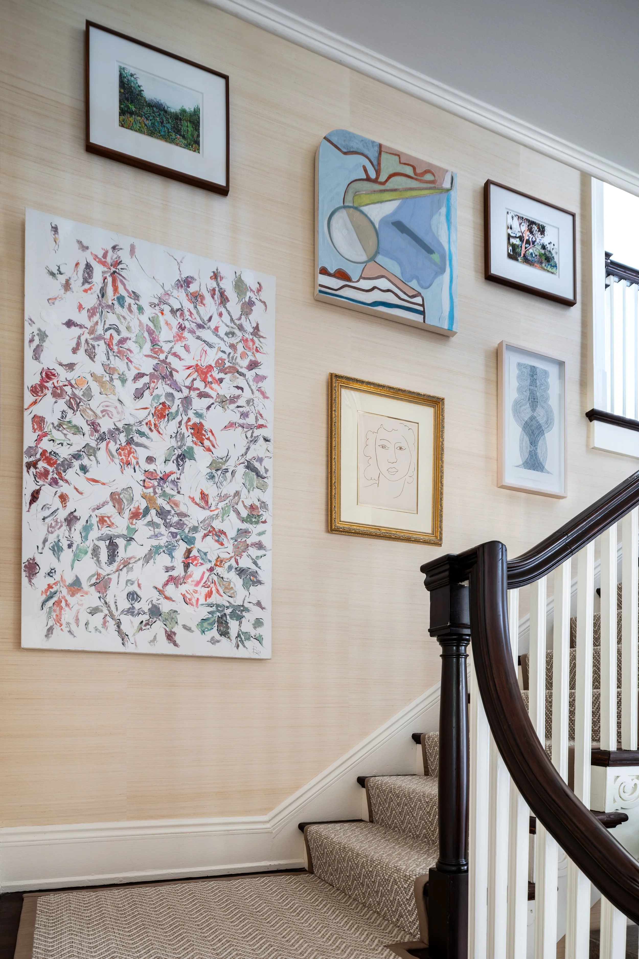 Stair hall featuring a curated gallery wall, classic millwork, and traditional architectural details.