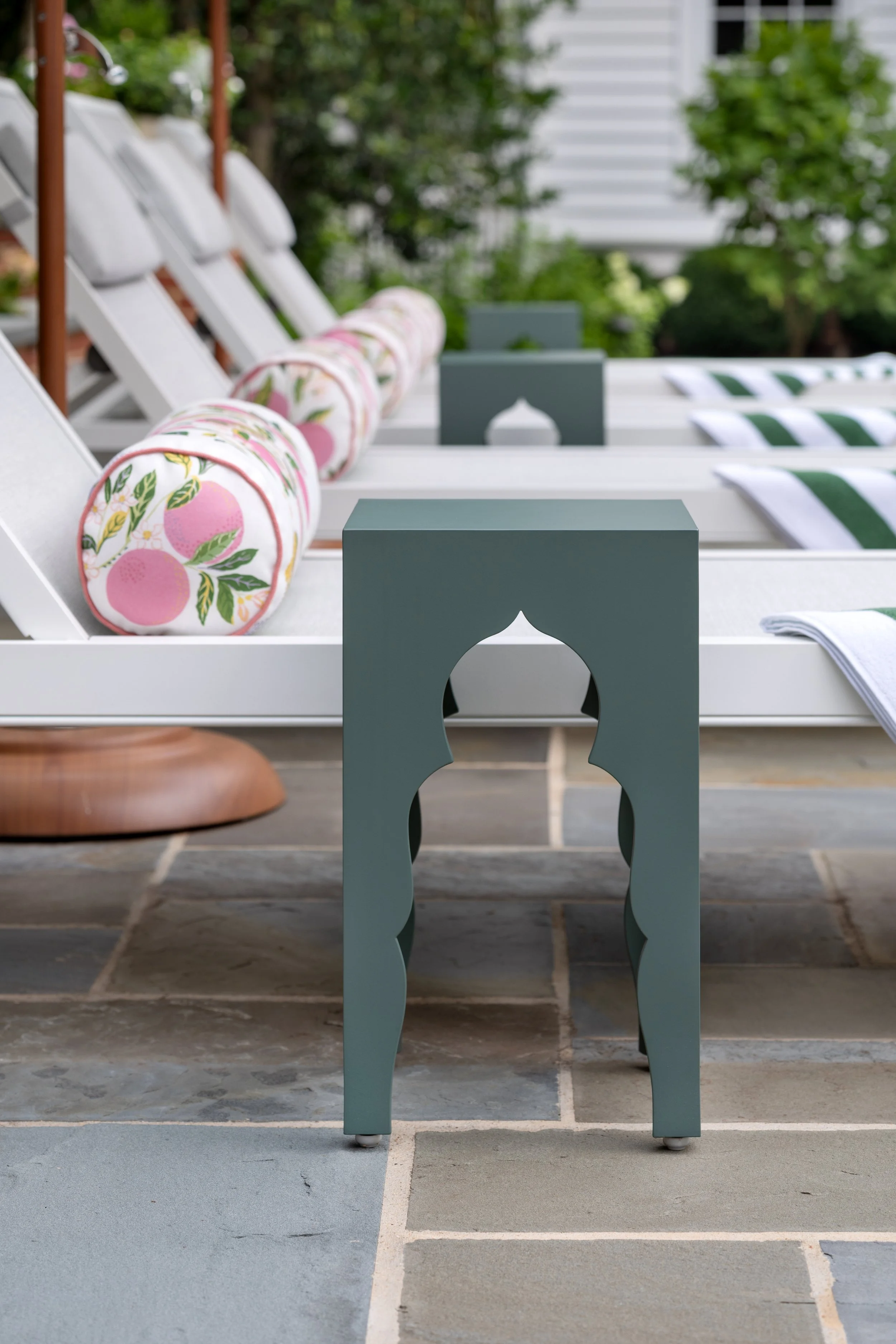 Custom sleek accent table by pool chaise.