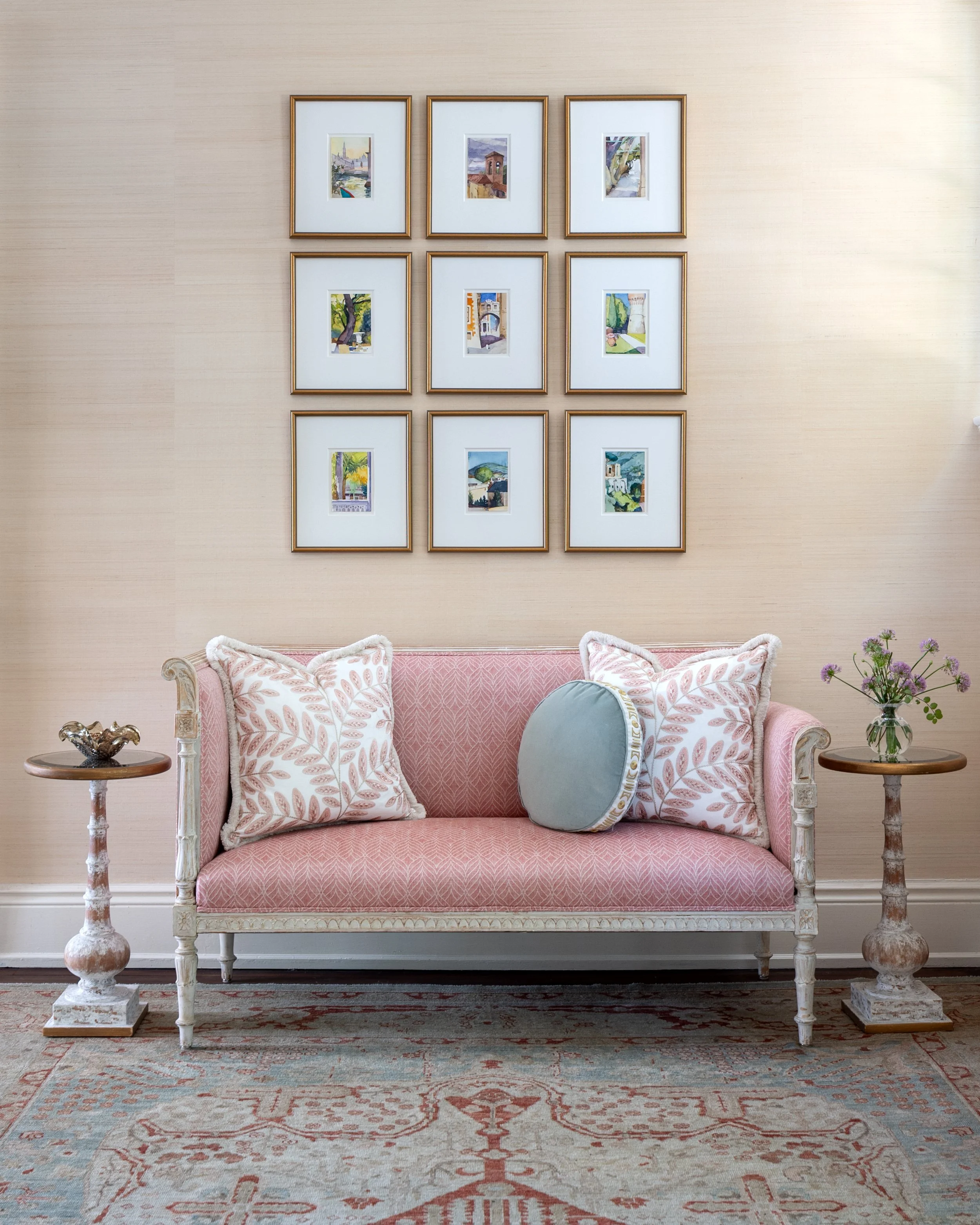 Collected Foyer with an antique upholstered settee, gallery wall, layered textiles, and traditional furnishings.