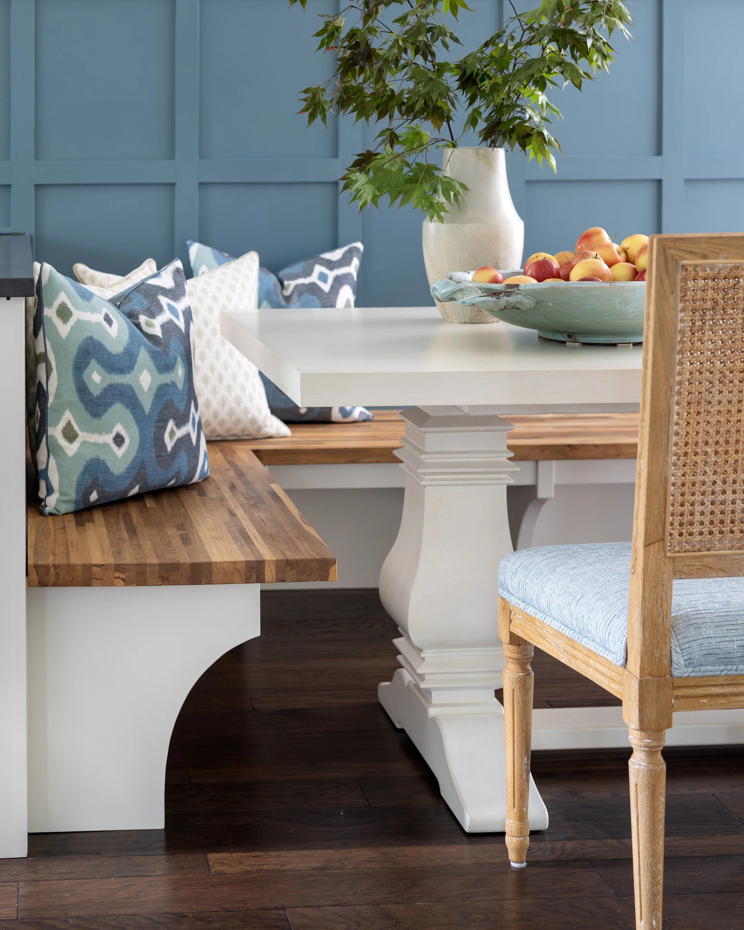 Dining room vignette featuring layered natural textures, paneled walls, and thoughtfully styled accessories.