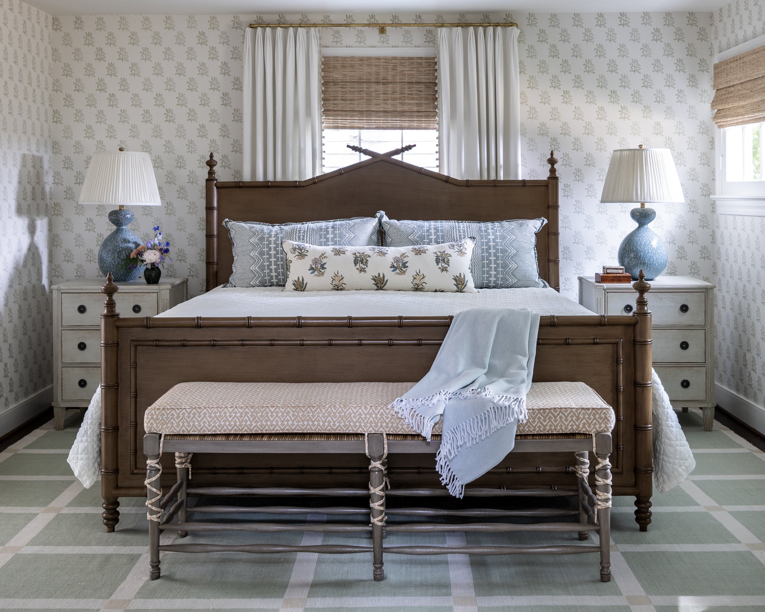 Guest bedroom featuring a custom wood bed, tailored bedding, layered textiles, and classic furnishings.