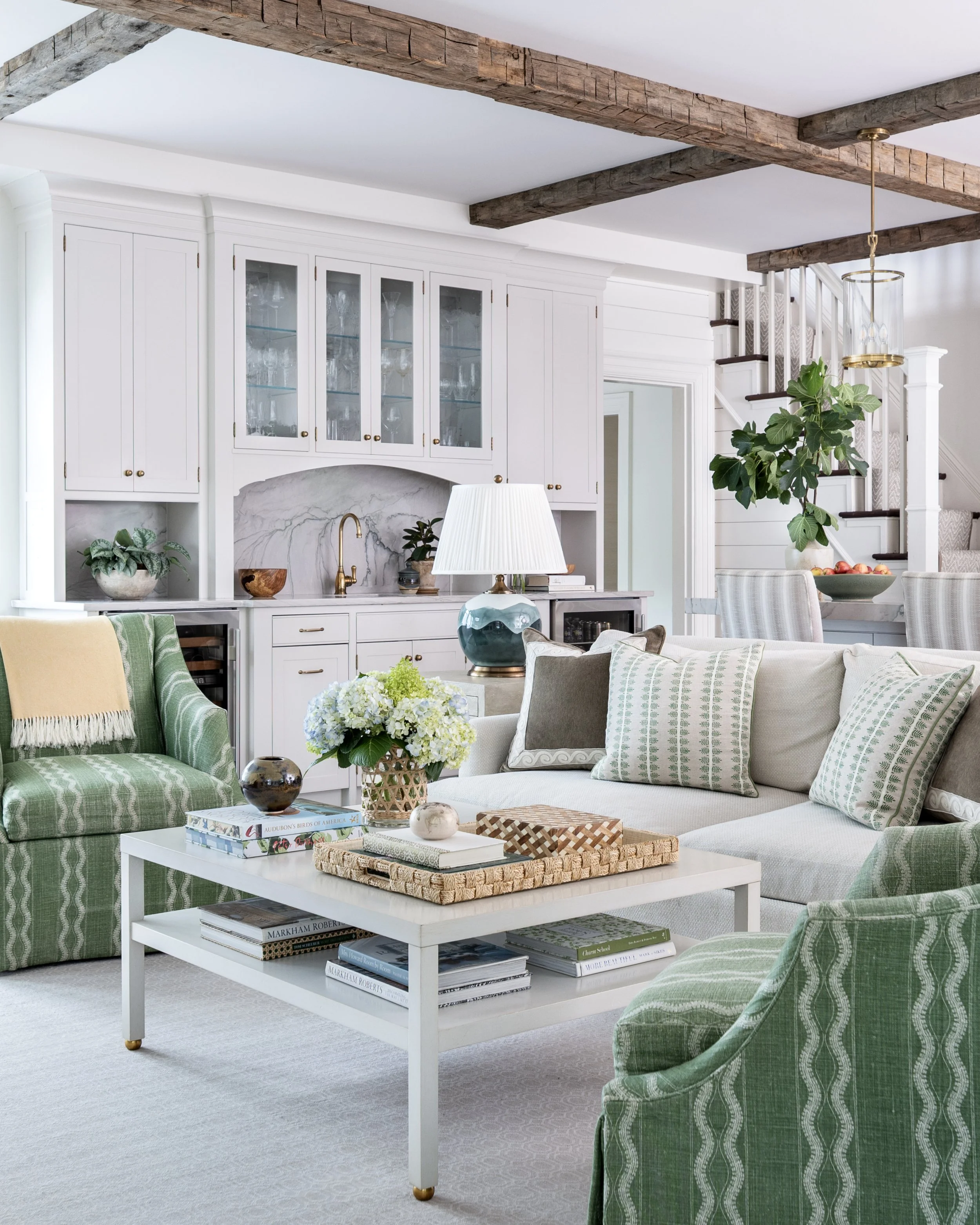 Family room featuring exposed ceiling beams, tailored furnishings, and layered natural textures.