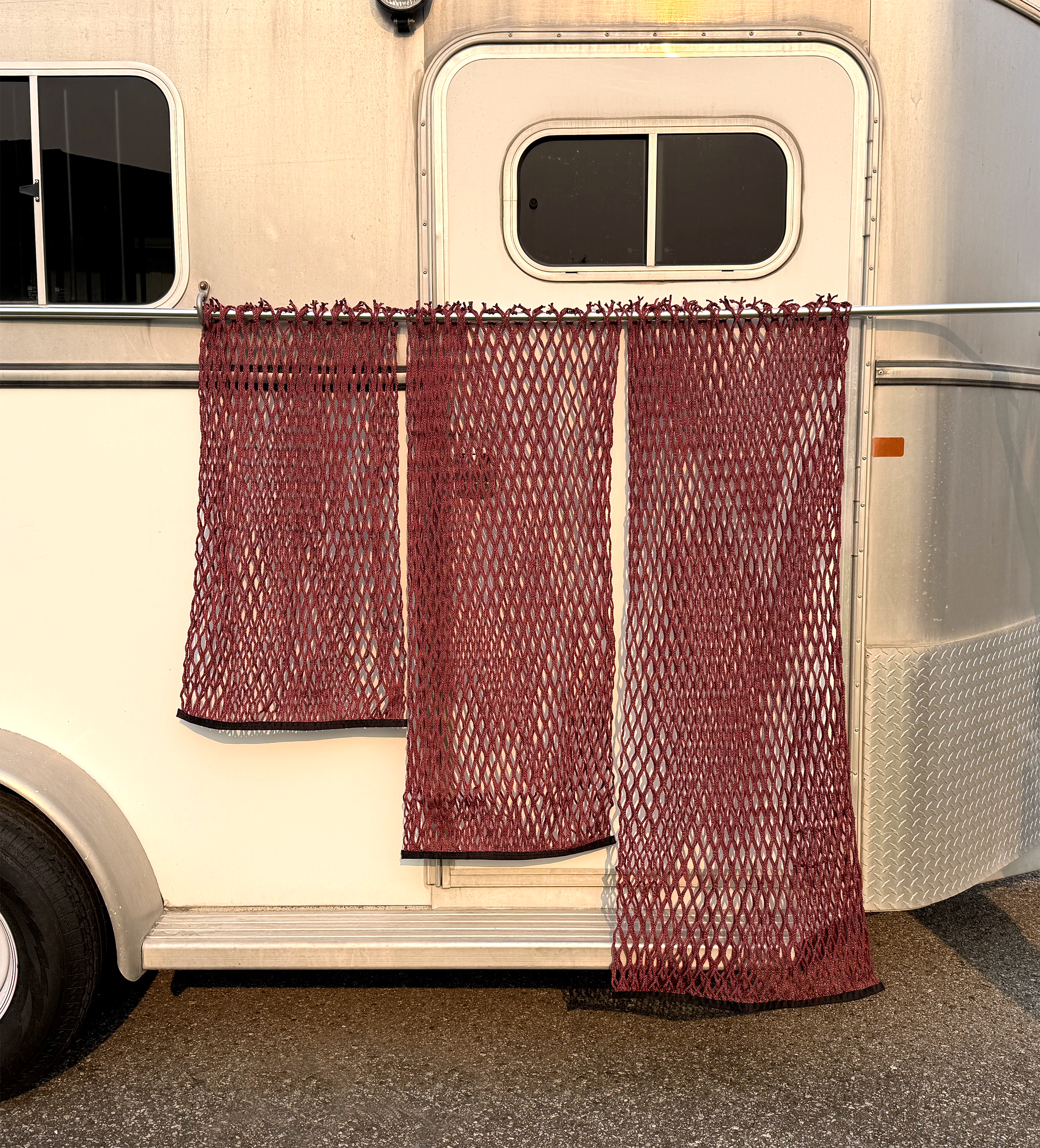 HayPal-flat-bottom-hay-nets-3-sizes-infront-of-horse-trailer.png