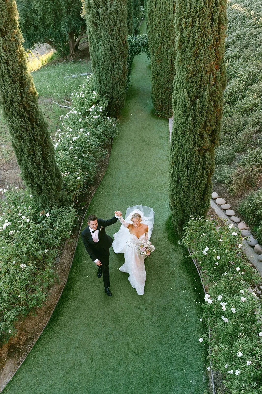 aerial_newlyweds_walking_garden_vineyard_valle_de_guadalupe.jpg.jpg