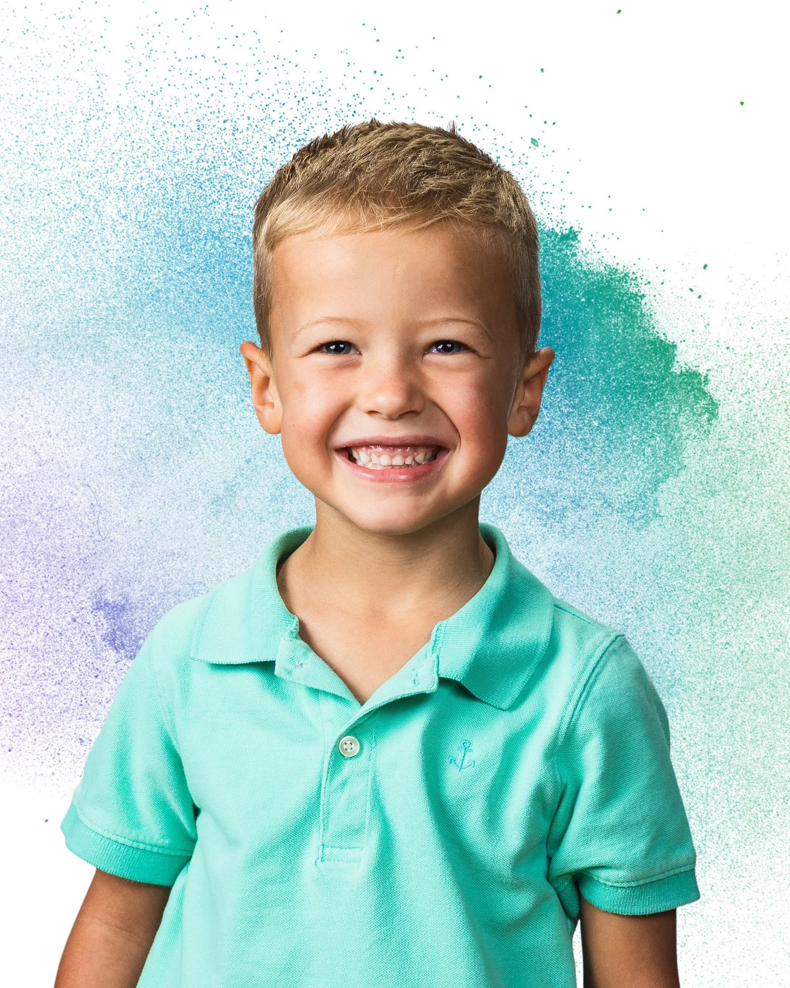A young boy with short blond hair and a big smile, wearing a light turquoise polo shirt, standing in front of a colorful, splattered paint background.