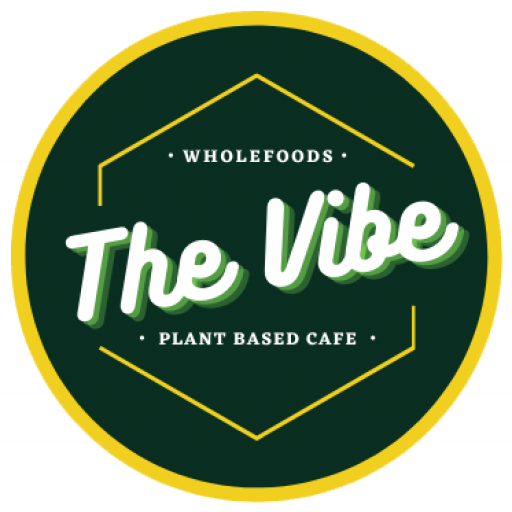 Logo for The Vibe, a plant-based cafe, with a green background, yellow border, and white text.