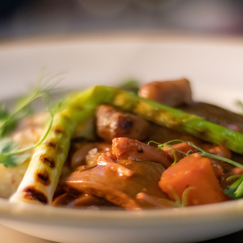 Close-up of cooked chicken and grilled asparagus in a white bowl