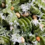 Close-up of a green garden salad with lettuce, cucumber slices, and white cheese crumbles.