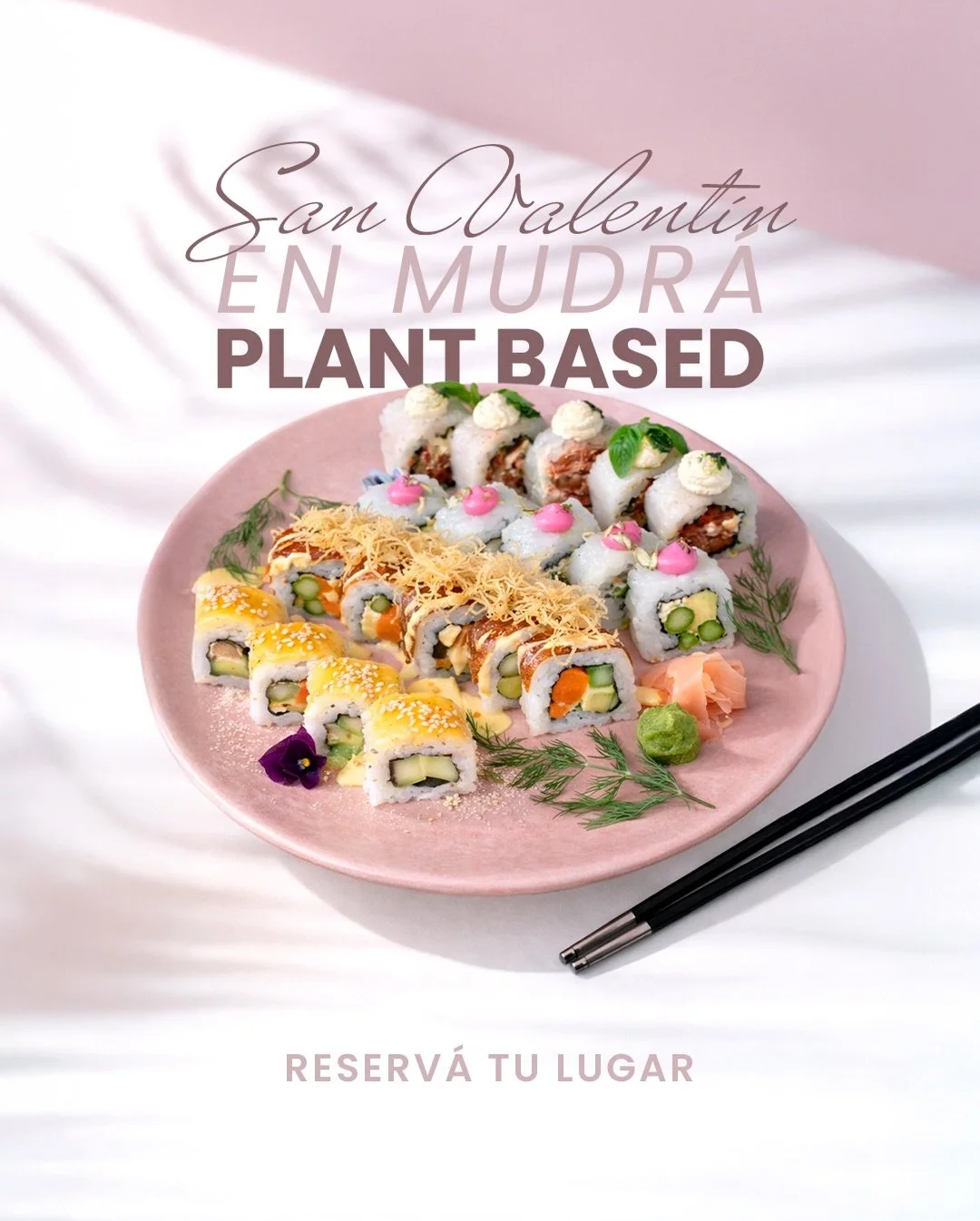 Plate of various vegan sushi rolls decorated with garnishes and wasabi, placed on a pink dish with a pair of chopsticks beside it.
