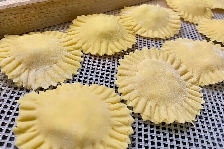 Uncooked ravioli pasta on a silicone baking mat.
