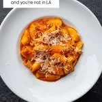 A plate of spaghetti with marinara sauce and grated cheese
