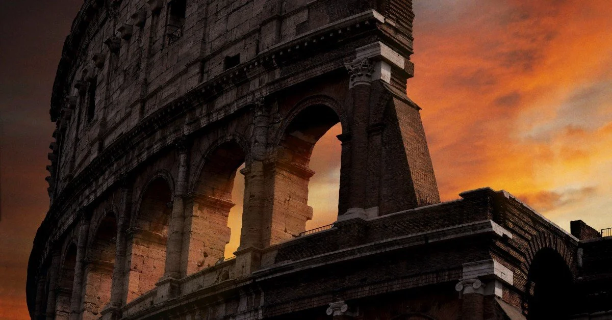 Close-up of the Colosseum at sunset with an orange sky