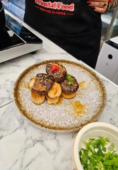 Plate of plated dim sum buns with detailed toppings in a restaurant setting.