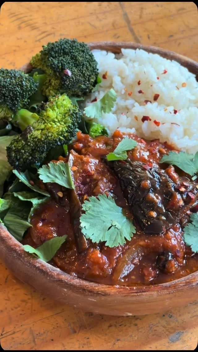 Vegetable curry with broccoli, cauliflower, rice, and cilantro in a wooden bowl.