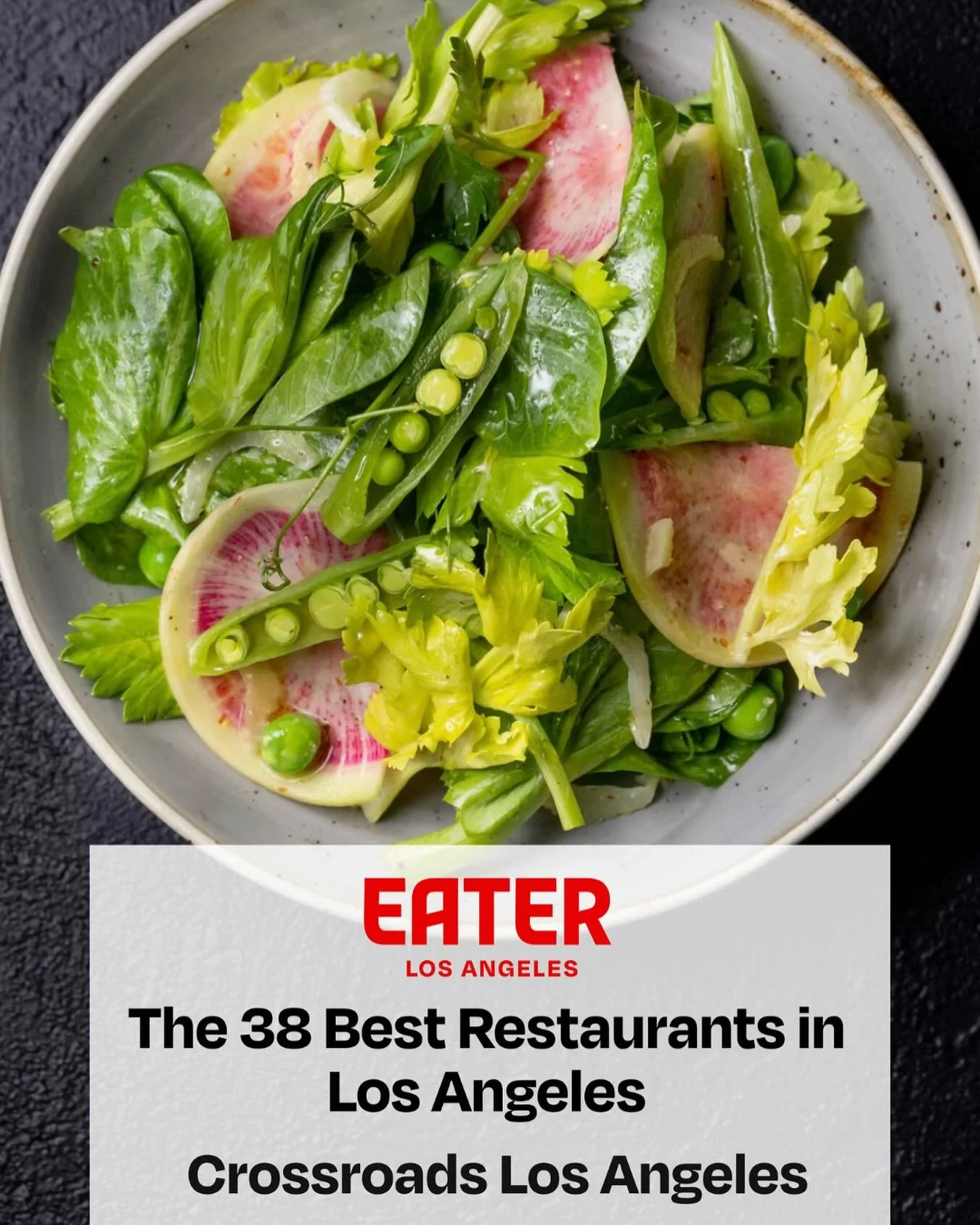 A bowl of fresh green salad with slices of watermelon radish, snap peas, peas, and various leafy greens.