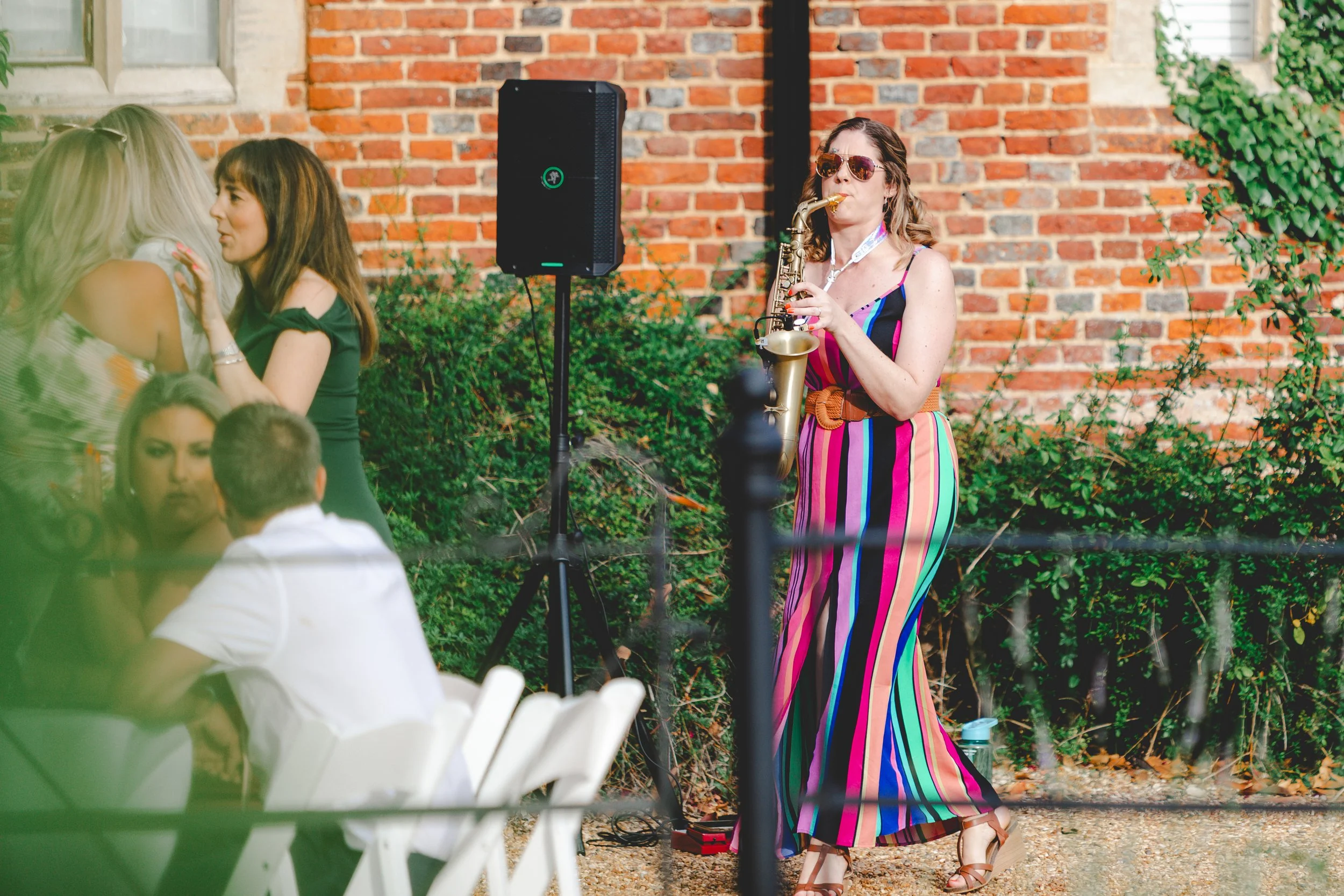 Female saxophonist plays during drinks reception at St Osyth's Priory