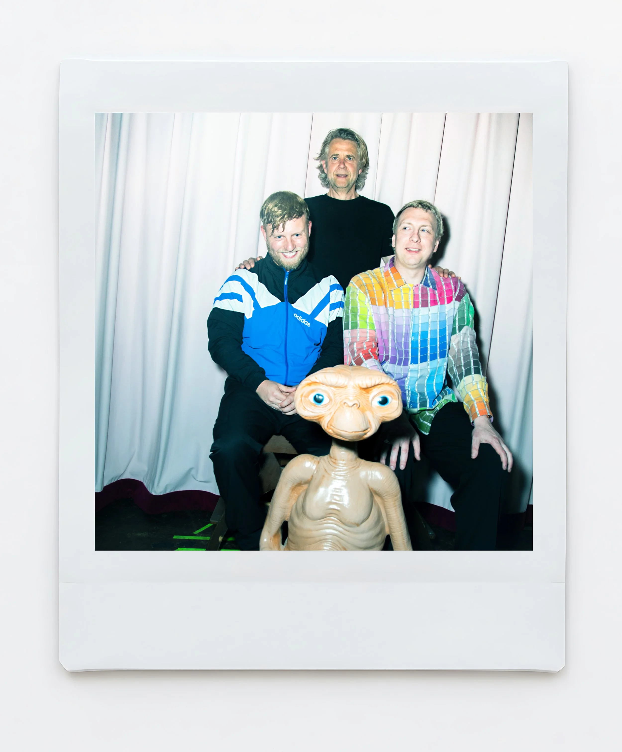 A male comedian Joe Lycett wearing a colourful shirt and next to a model of E.T and a cardboard cutout of Cher photographed backstage at the Crookes Socila Club Sheffield Karina Lax at The Comedy Village, Sheffield