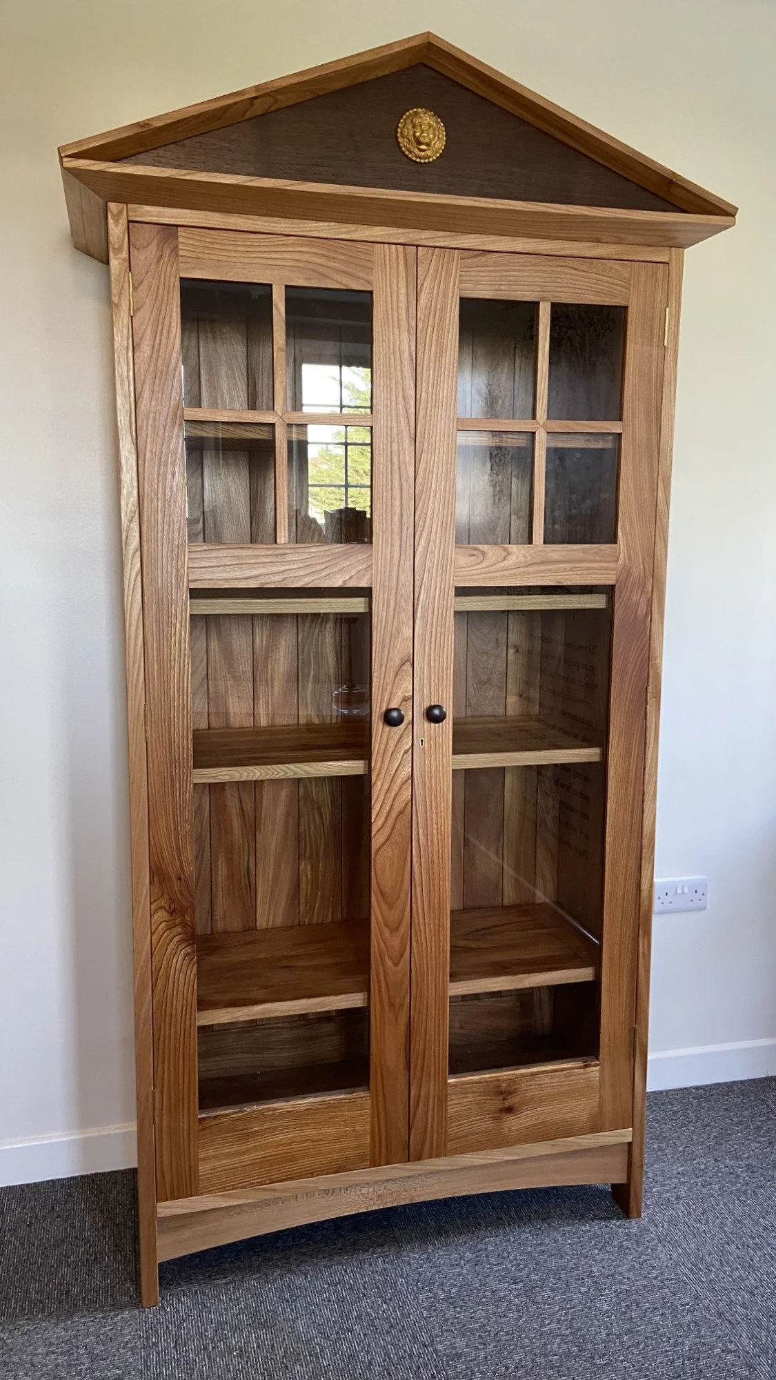 Bespoke C.S. Lewis-Inspired Bookcase

A handmade glass-fronted bookcase, designed with classical proportions and architectural detail. Crafted from solid timber with glazed doors, shaped mouldings and a pediment top, it creates a refined place to dis