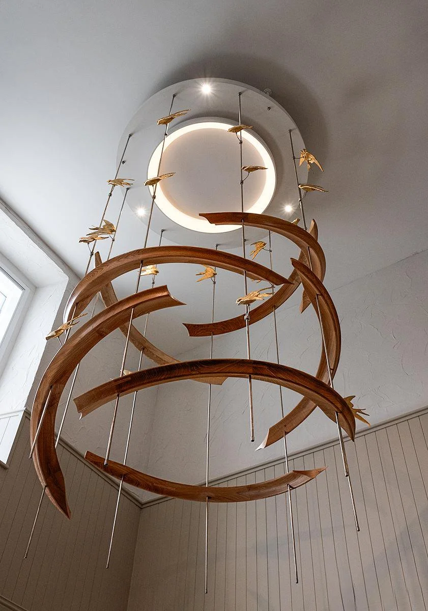 Bespoke Courthouse Lighting Sculpture

A large suspended lighting sculpture created from sweeping hardwood forms, polished metal rods and gilded swallows. Designed to rise through the space beneath the circular light, the piece brings warmth, movemen