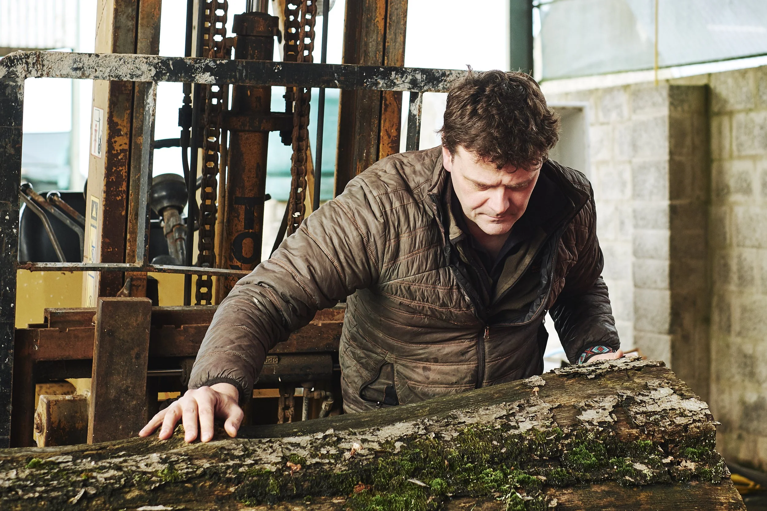 noel mccullough loading a log on to the sawmill prior to palnking it for wood to make furniture