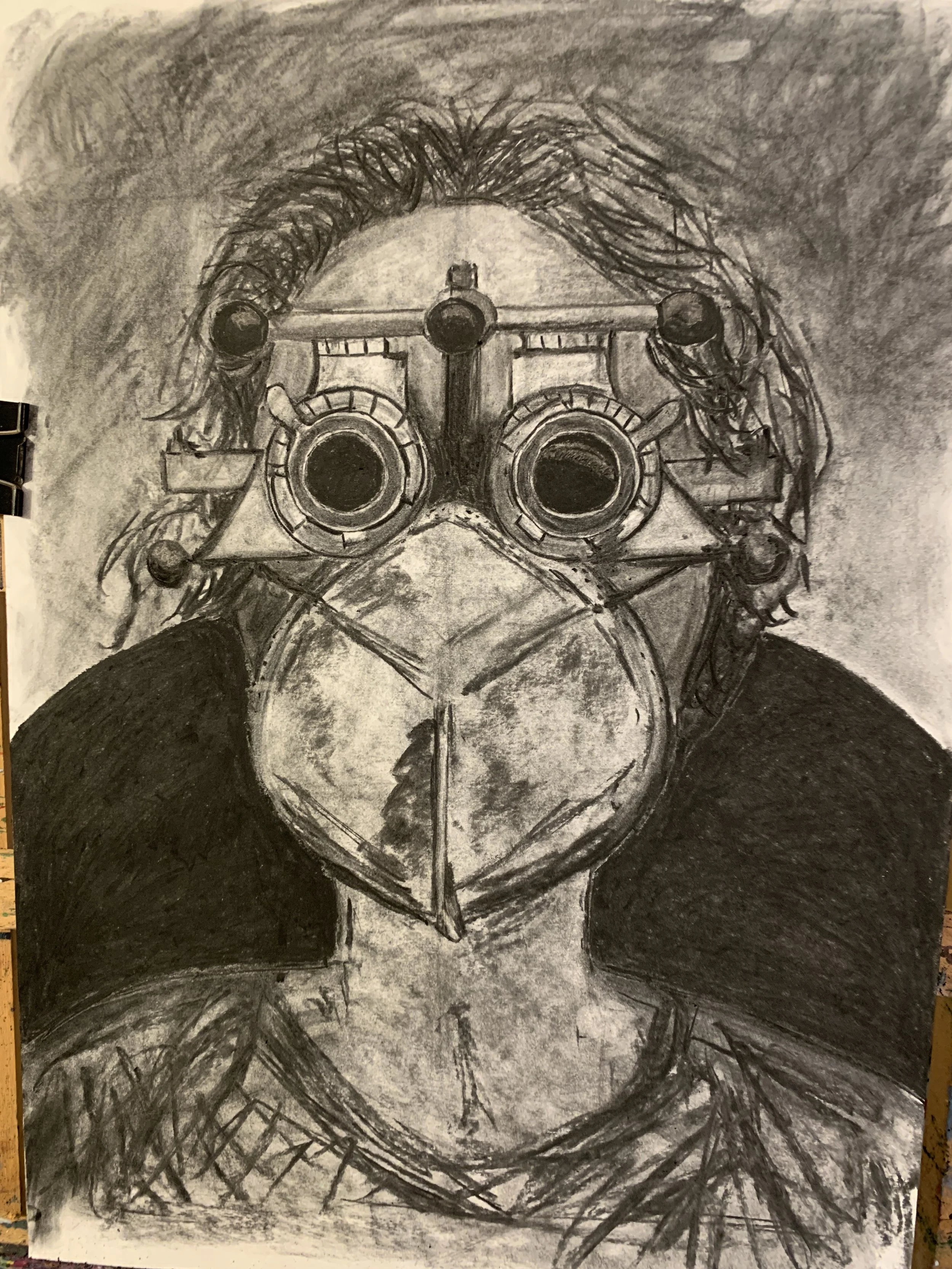 A monochrome pencil drawing of a person wearing goggles or a mask, viewed from above, with detailed shading and textured lines.