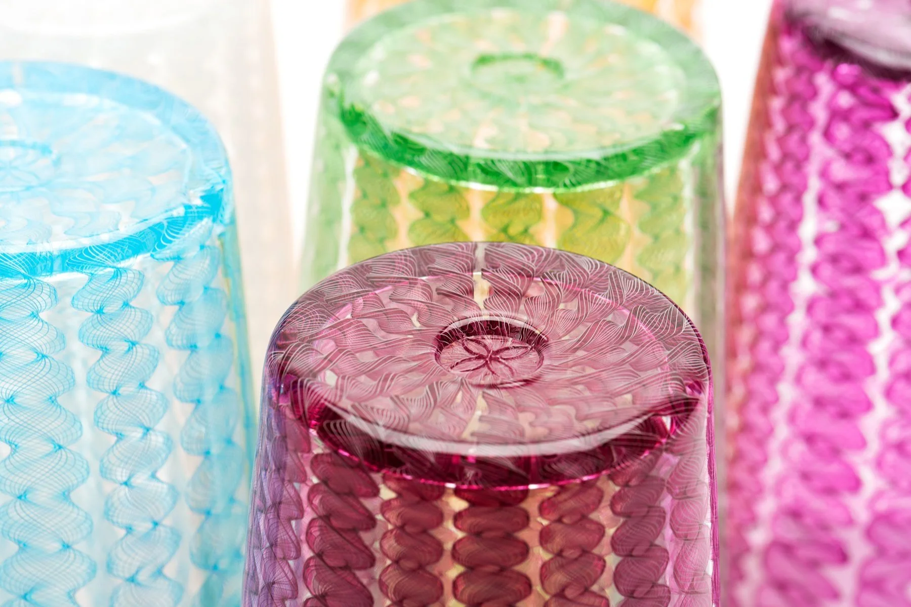 A detail of the bottoms of several colorful Xander D'Ambrosio twisty cane pint glasses. Image by Loam
