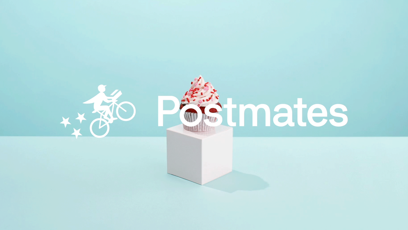 A cupcake with pink frosting and red sprinkles on a white pedestal against a light blue background. Overlaid text reads 'Postmates' with an illustration of a person riding a bicycle.