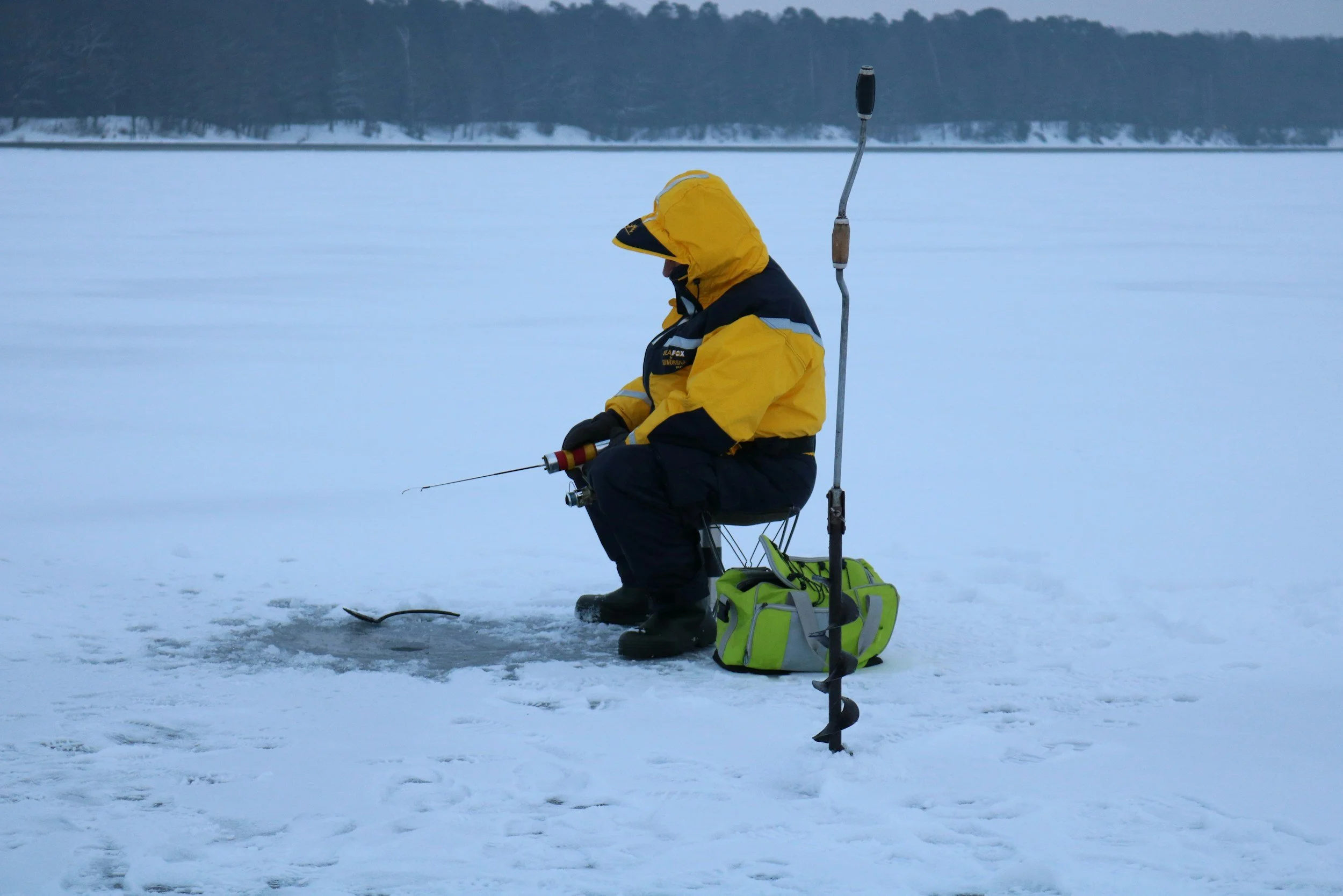 A person ice fishing on a frozen lake