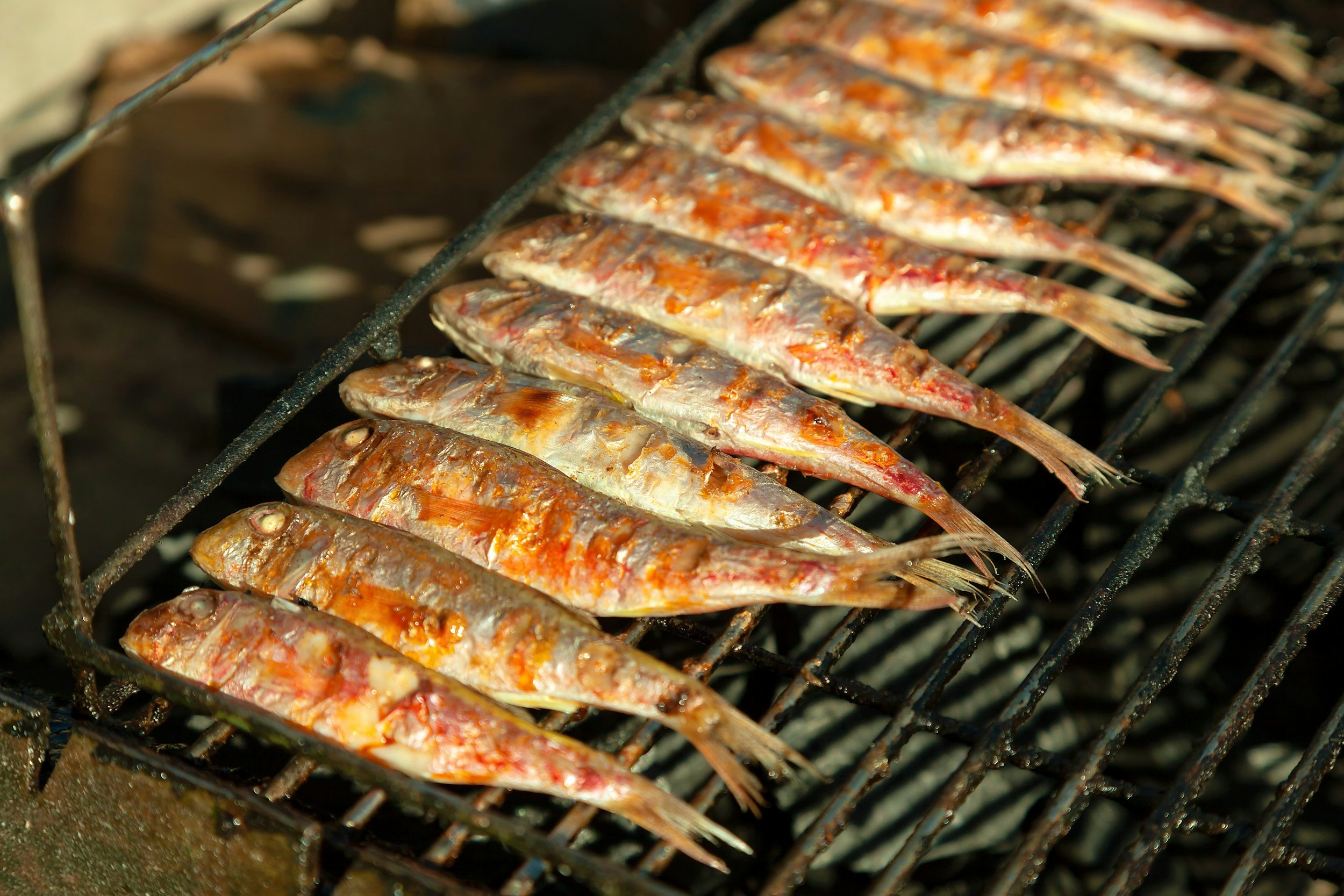Fish being grilled on a grill grate