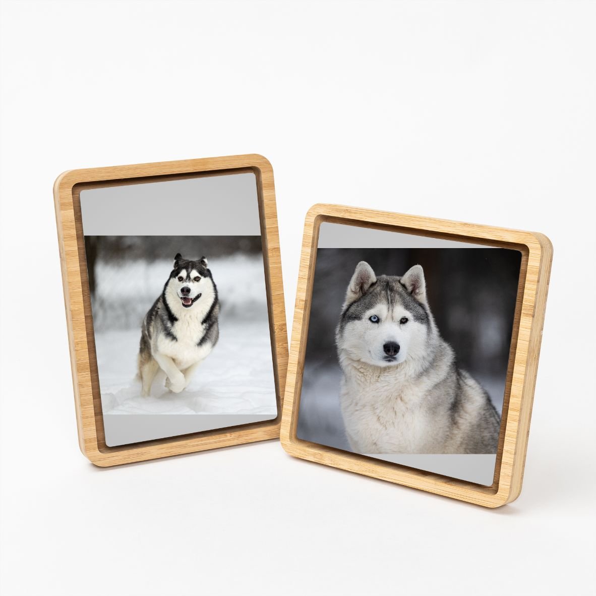 Two wooden picture frames displaying photos of Siberian Huskies, one running in snow and the other with a close-up of a Husky's face.