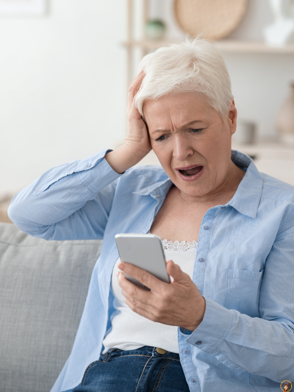 Older woman looking concerned while reading a message on her phone, illustrating the growing risk of online scams and financial exploitation of seniors.
