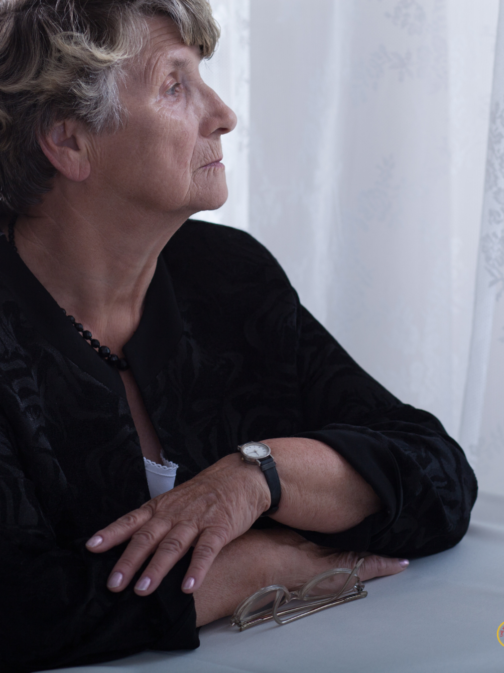 Elderly woman reflecting after loss while considering estate planning and probate issues in North Carolina