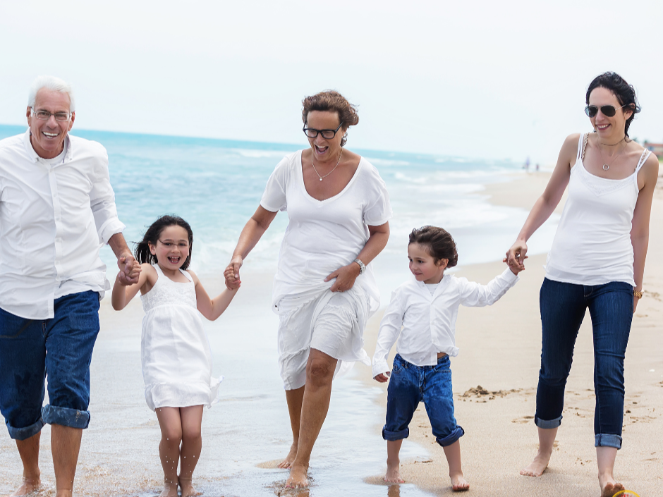 Multi-generational family walking together on the beach, representing the peace of mind that comes from estate planning and protecting your family's future.