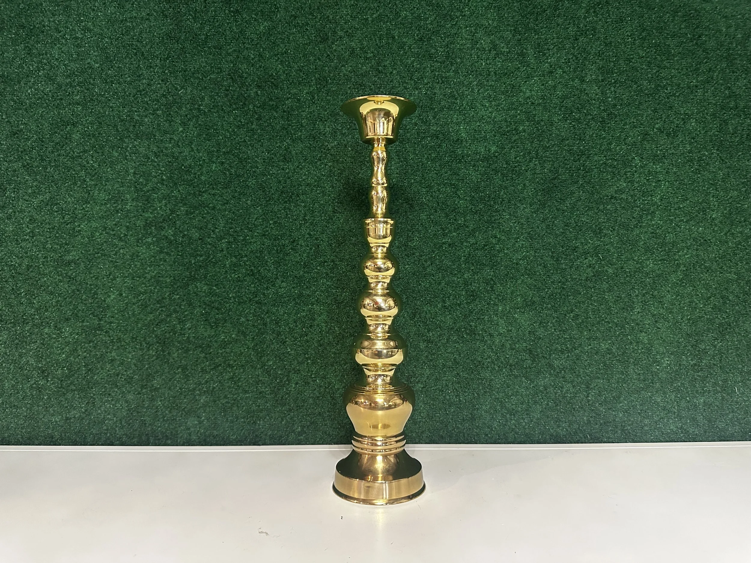 Tall brass column candle holder styled with taper candle and greenery for wedding tablescape