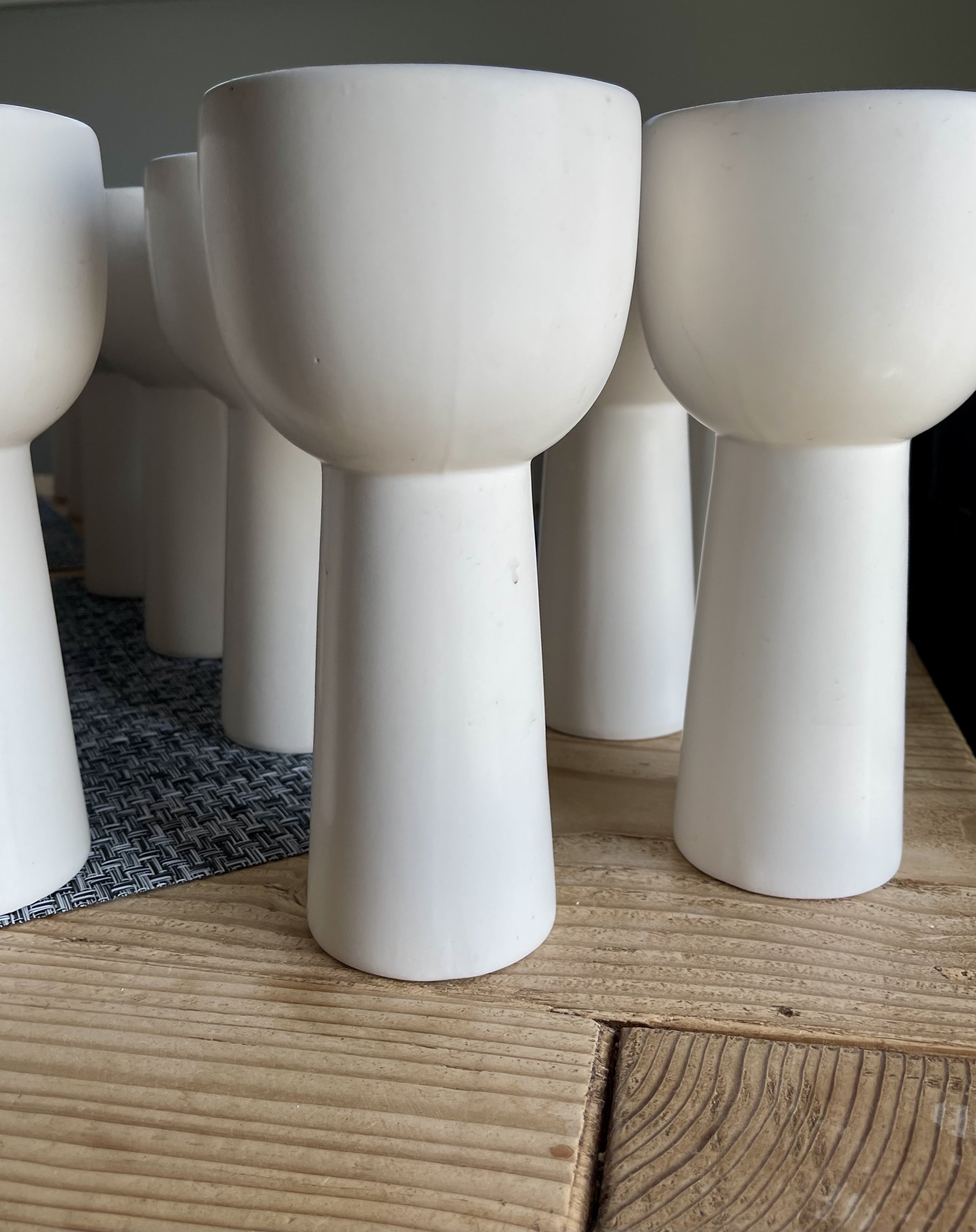 White ceramic candle holders on a wooden surface