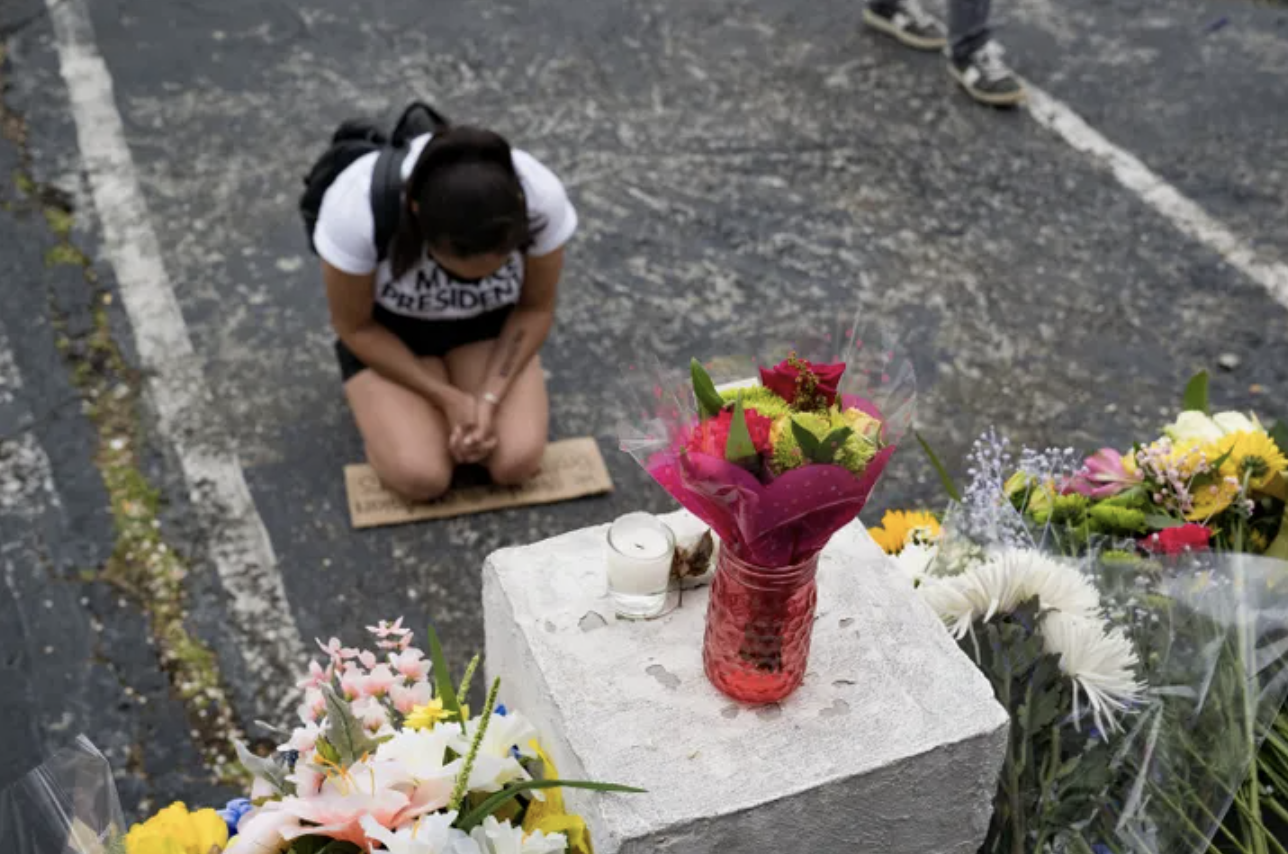 Flowers and signs adorn Gold Spa in Atlanta, where people protested violence against women and Asians following the shootings that took eight lives
