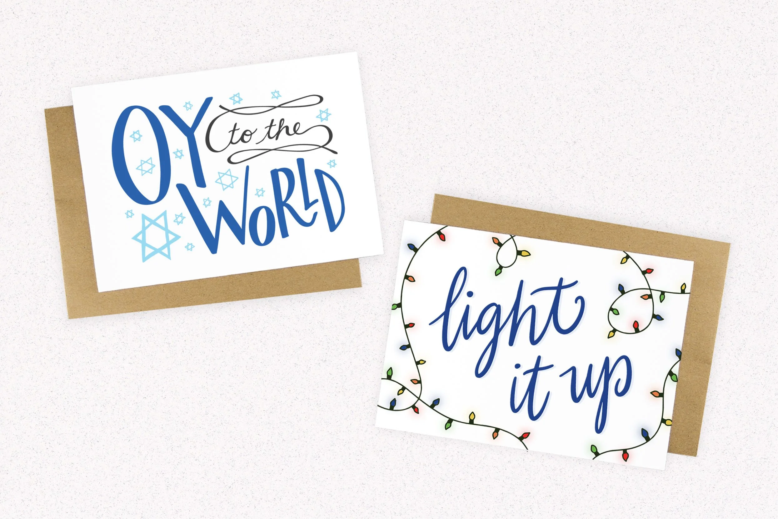 Hand lettered and illustrated greeting card designs: Oy the World Hanukkah, and light it up christmas lights