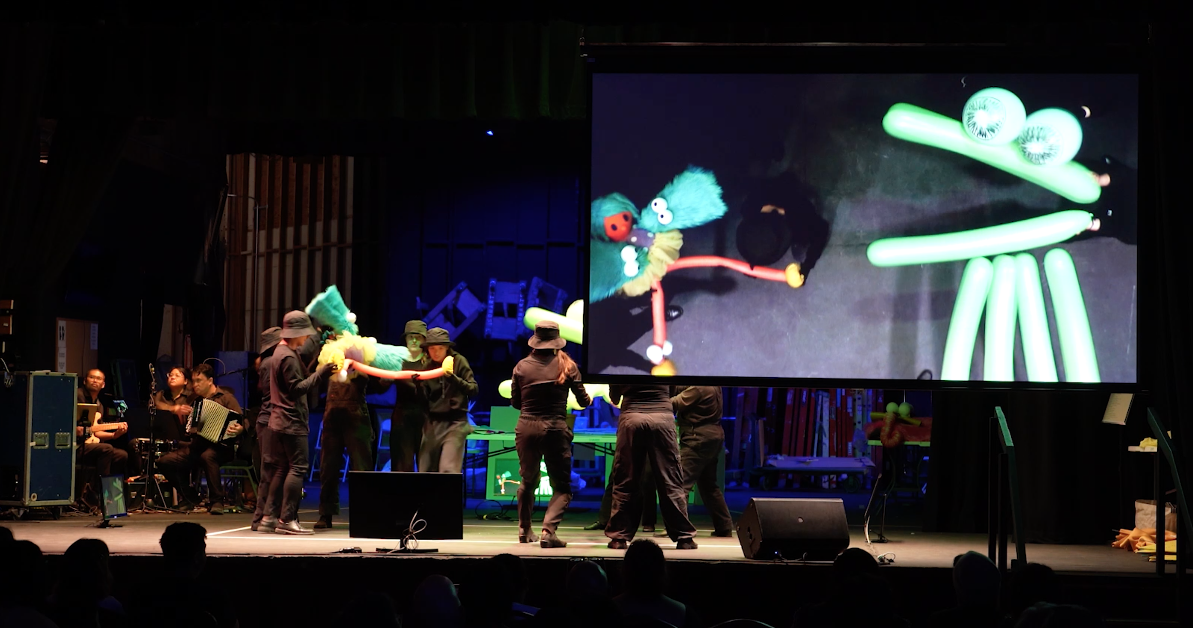Audience view of the stage and video projection screen