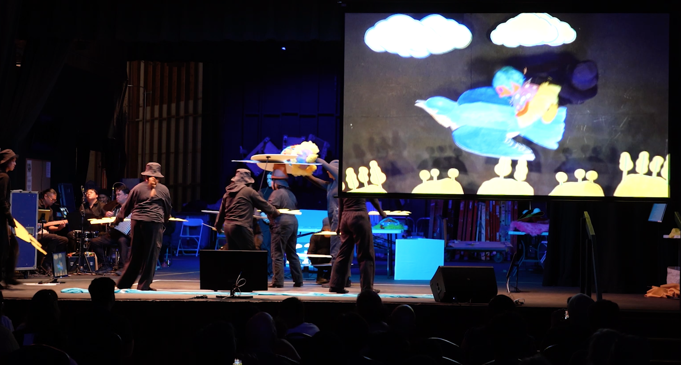 Audience view of the stage and video projection screen